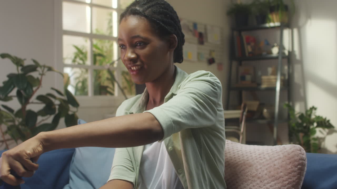 Young African American woman playing video games at home