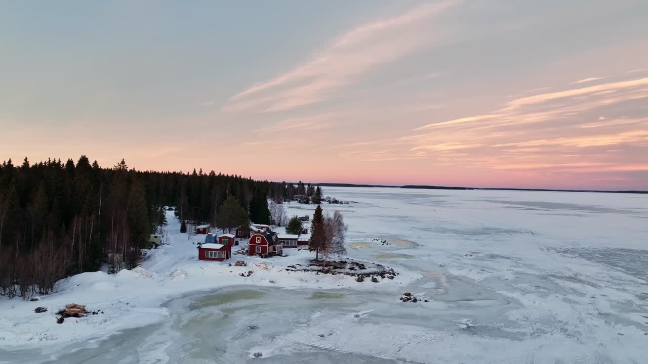 Crepúsculo sobre la Bahía de Botnia cubierta de nieve con casas rojas, Luleå, Suecia, vista aérea