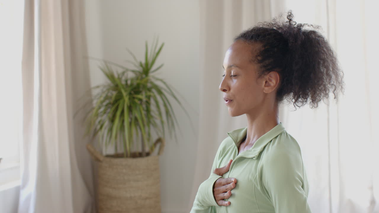 woman smiling while holding water bottle during home workout