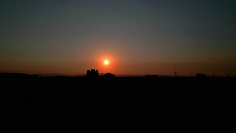 Dramatic-Scene-Of-Nature-Silhouettes-During-Sunset---aerial-wide-shot