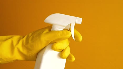 cleaning spray bottle with yellow gloves