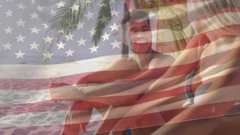 american flag animation over people relaxing on sandy beach under palm trees