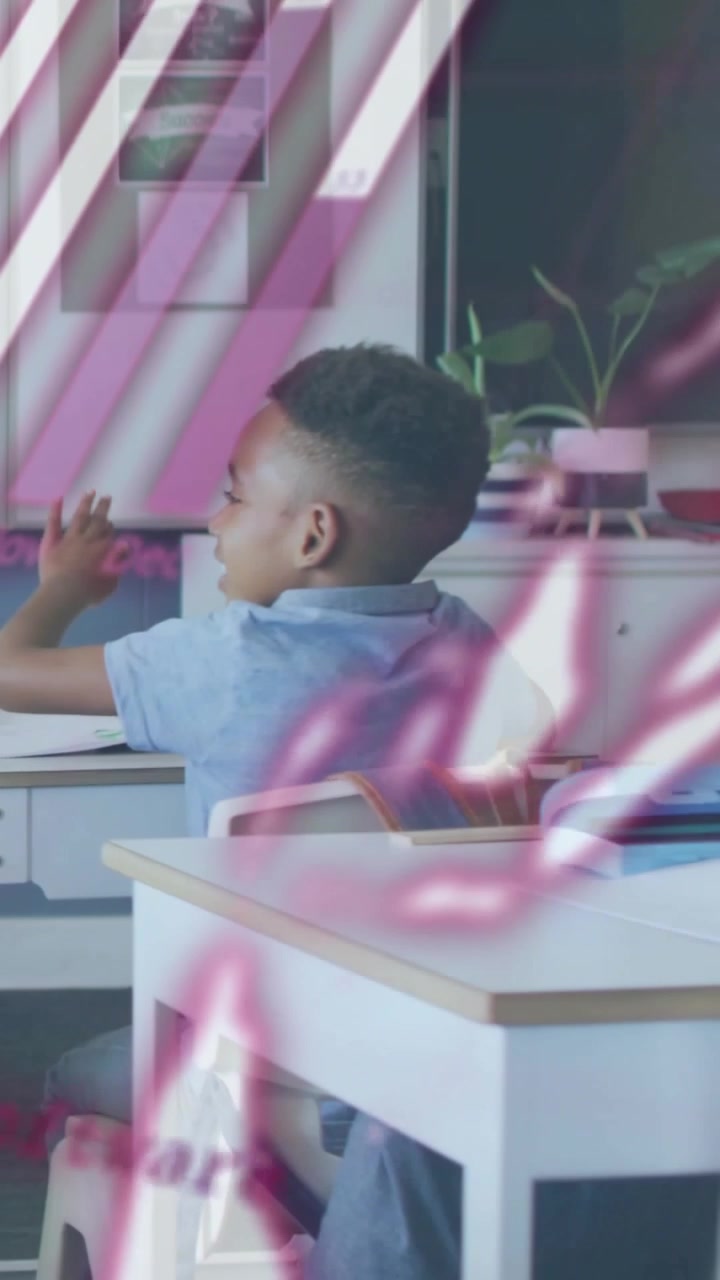 Teacher helping and pointing, student shifting and writing while pink graphics overlaying classroom