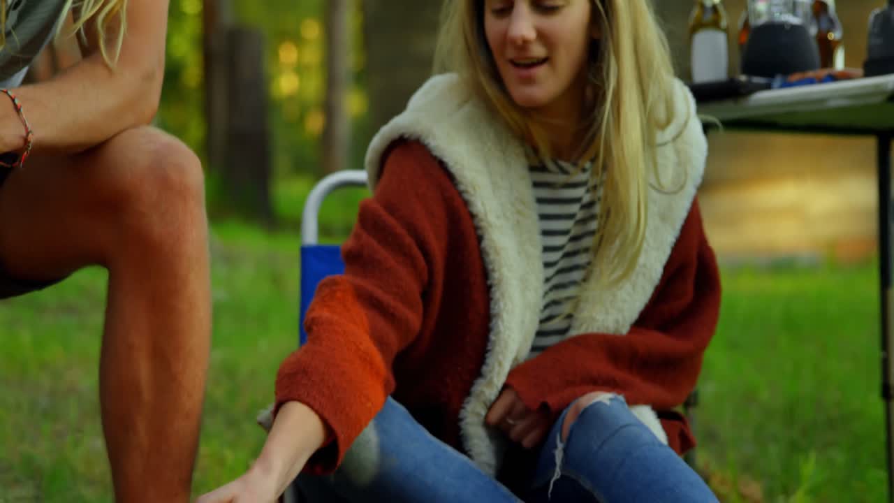 amigos asando malvaviscos en el fuego del campamento 4k