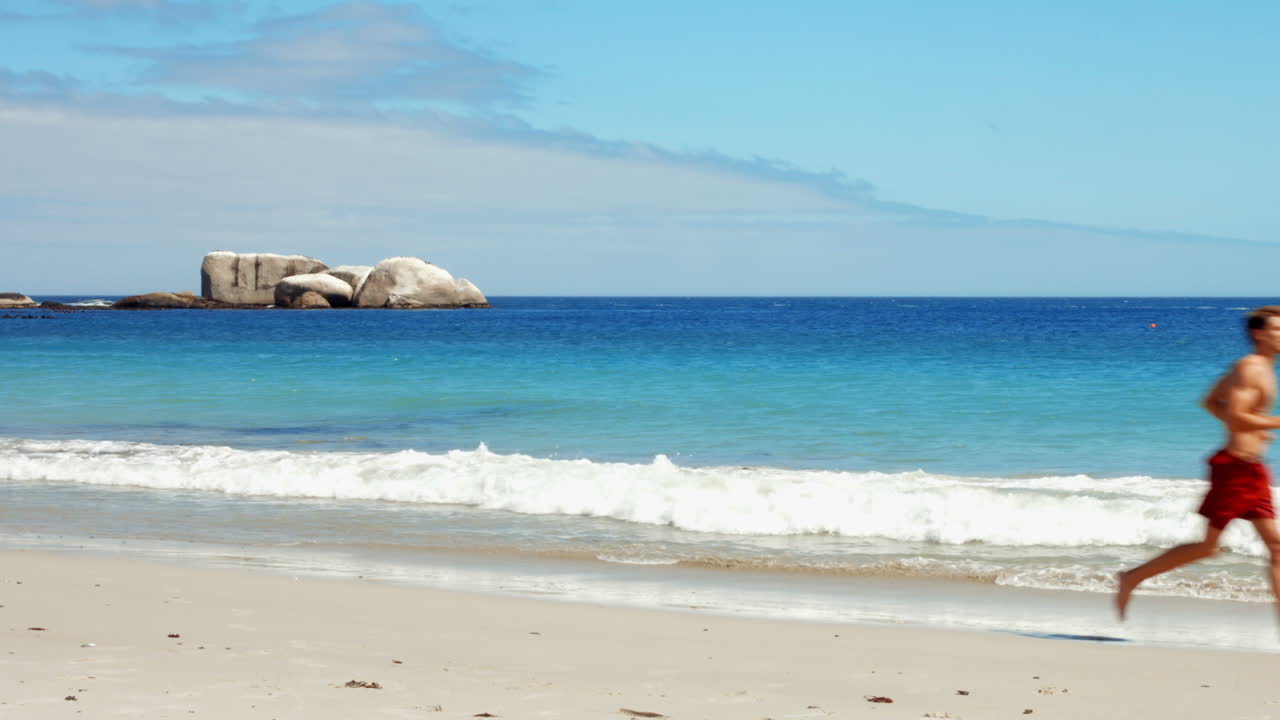 Fit man jogging on the beach