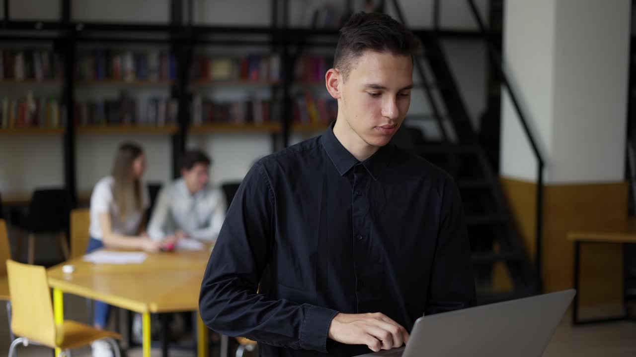 un joven estudiante serio camina por la biblioteca con una computadora portátil, pensando en la inspiración, encontrando soluciones a problemas, ideas