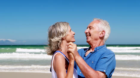 una pareja de mayores disfrutando juntos en la playa.