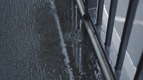 a close up of raindrops dripping into a puddle on a walkway