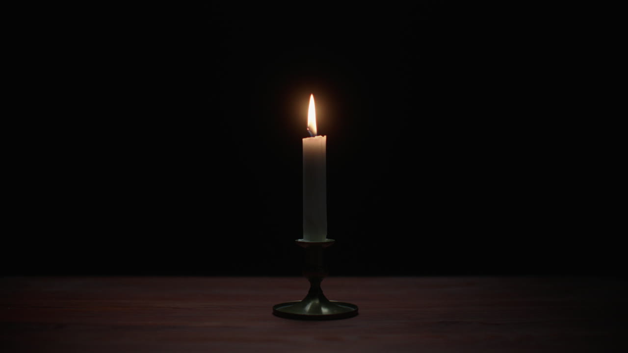 A candle burs out in the dark room