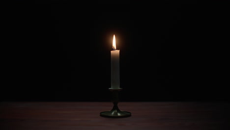 a candle burs out in the dark room
