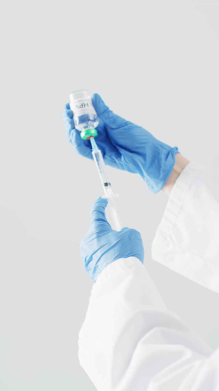 video vertical de las manos de un médico caucásico preparando la vacuna contra el hpv, con espacio para copiar