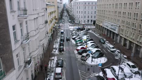 Vista-Aérea-De-Un-Coche-Conduciendo-Por-Las-Calles-Nevadas-De-Varsovia,-Invierno-En-Polonia---Estático,-Tiro-De-Drones