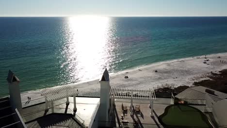 tourists relaxing at the beach with sunlight reflection in the ocean at summer in panama city beach, florida, usa. - aerial