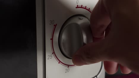 Hand-Turning-Off-Microwave-Oven-Timer-Control-Knob