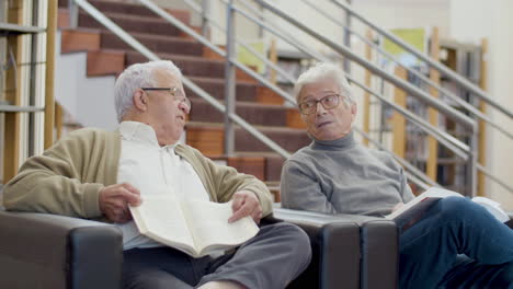 elderly caucasian men sitting in library and talking