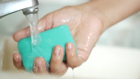 lavarse las manos con jabón bajo agua corriente
