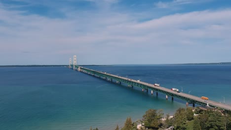 cargo freight trucks drive over long suspension bridge over atlantic ocean water