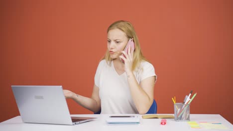 Mujer-Usando-Una-Computadora-Portátil-Hablando-Nerviosamente-Por-Teléfono.