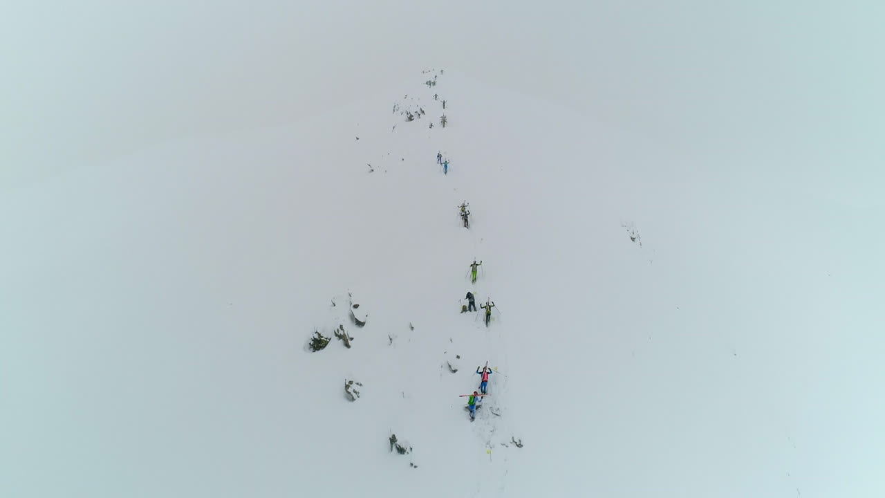 전문 산악 트레커 들 이 추운 눈 인 산길 에서 산 을 올라 고 있는 모습 을 드론 으로 찍은 사진
