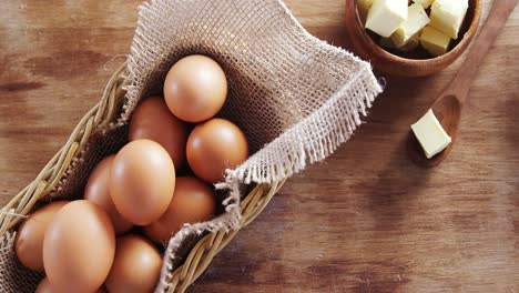 huevos marrones y cubos de mantequilla en una mesa de madera 4k