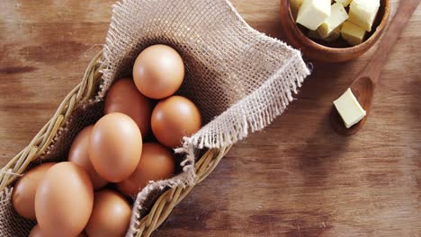 brown eggs and butter cubes on wooden table 4k