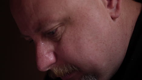 sad, unhappy, grieving, crying man looking at his phone alone in his apartment