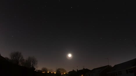 una luna de invierno que pasa a través de un cielo estelar a la luz de las estrellas hacia un amanecer brumoso en el reino unido
