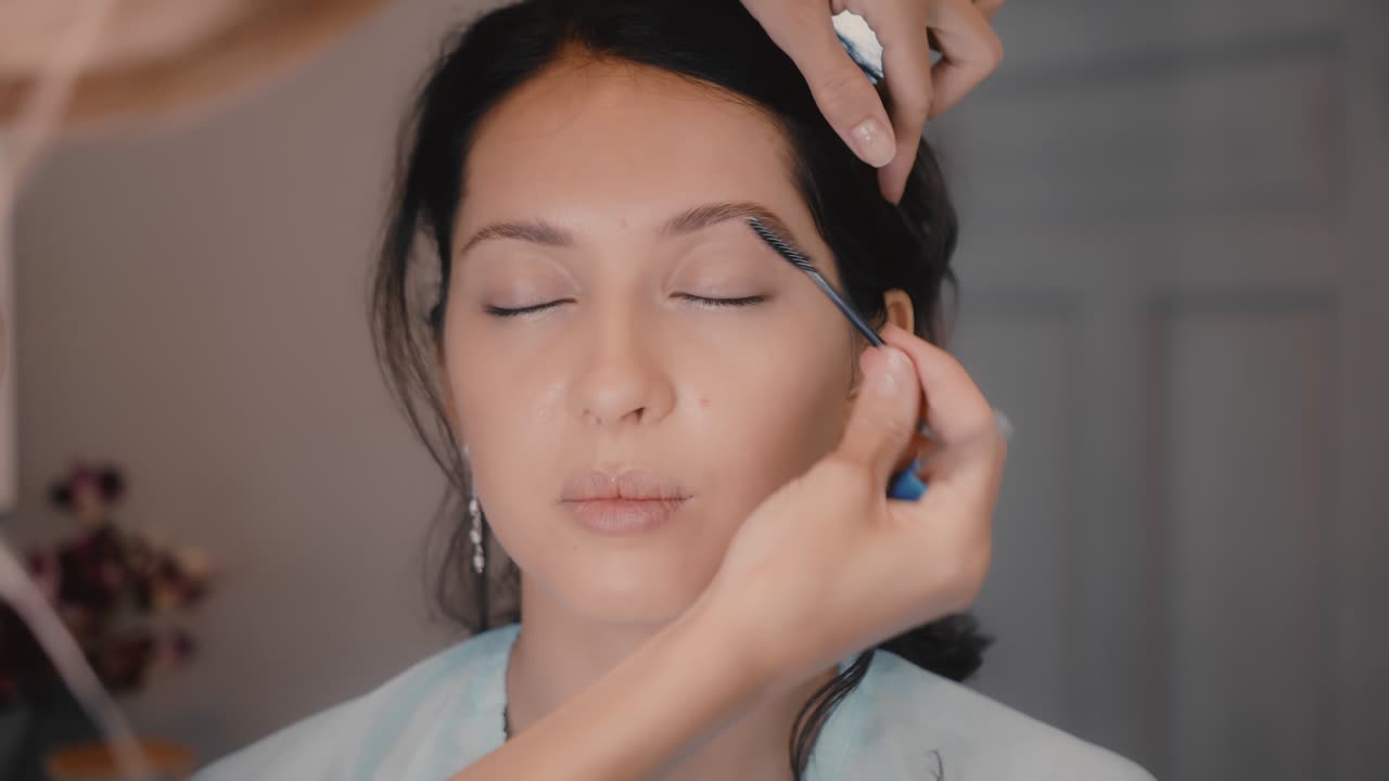 Woman getting her makeup done by a professional make-up artist