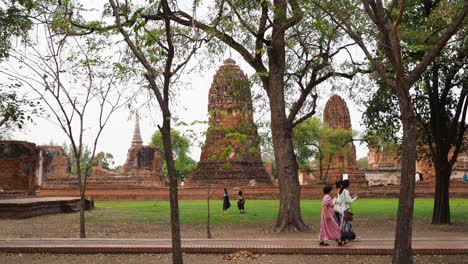 people walking near historic pagodas in ayutthaya, thailand