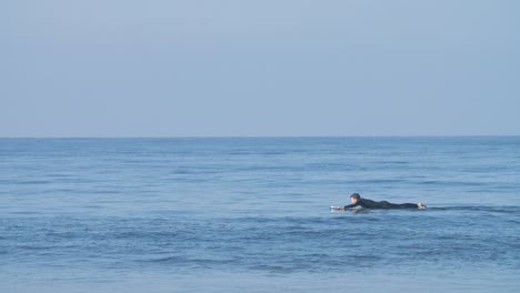 Surfer-Paddling-Surfboard