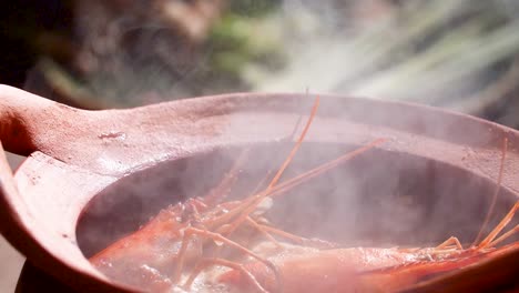 sopa de camarón caliente al vapor servida en una olla de arcilla tradicional, capturando la esencia de la cocina tailandesa, de cerca