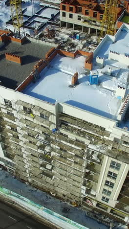 construction of building in winter. tall buildings under construction with cranes