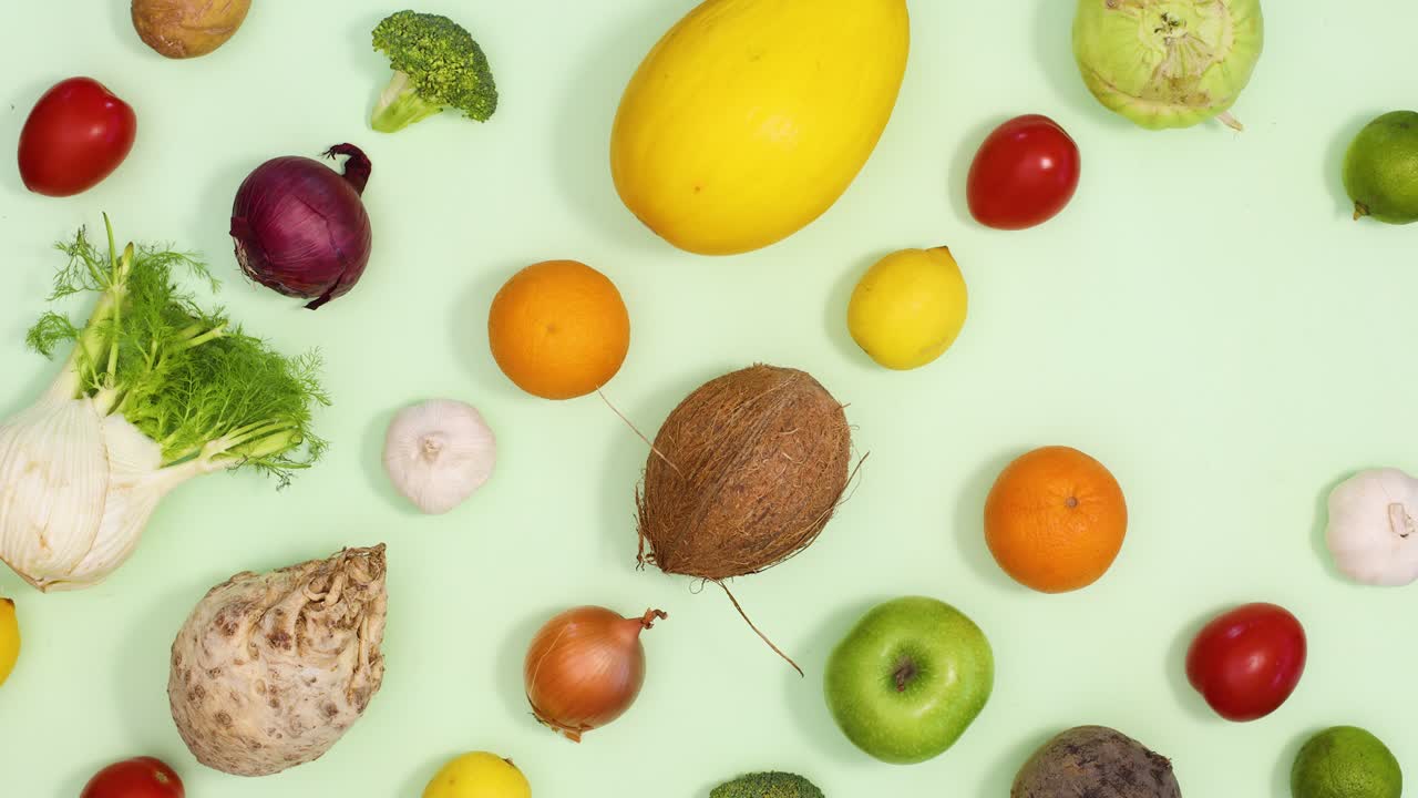 patrón creativo hecho de frutas y verduras parpadeando sobre un fondo verde claro. detener el movimiento