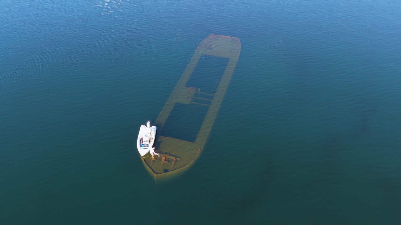 Aerial view circling a boat at a shipwreck at Lake Saimaa, summer in Finland