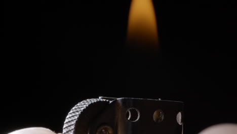 close up ignition of zippo lighter macro studio shot isolated on black background, slow motion