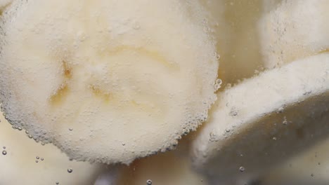 the banana slices under water with air bubbles.