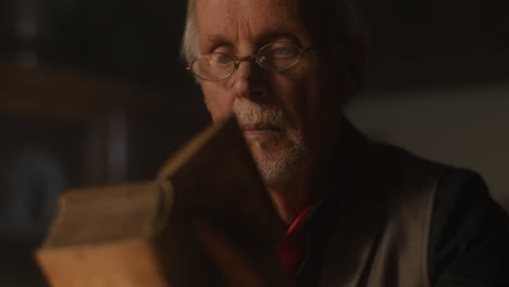 old passionate man read a book in his office at night
