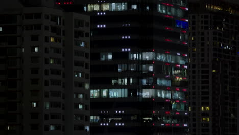 Light-Pollution,-Funky-Shiny-Glamming-High-Building-LED,-Dense-Modern-City-Central-Finance-Business-District-at-Night,-Red-Glooming-Skyscraper-Skyline