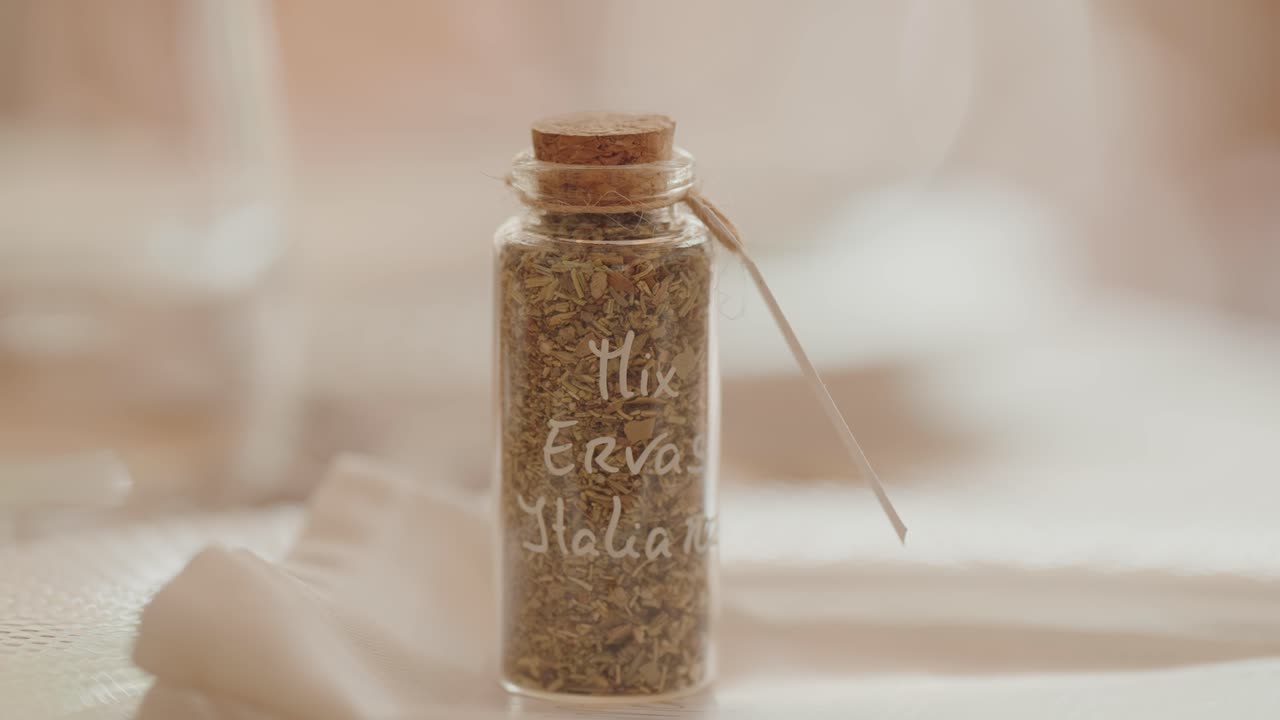 Close-up of small glass jar labeled Italian herb mix with cork lid