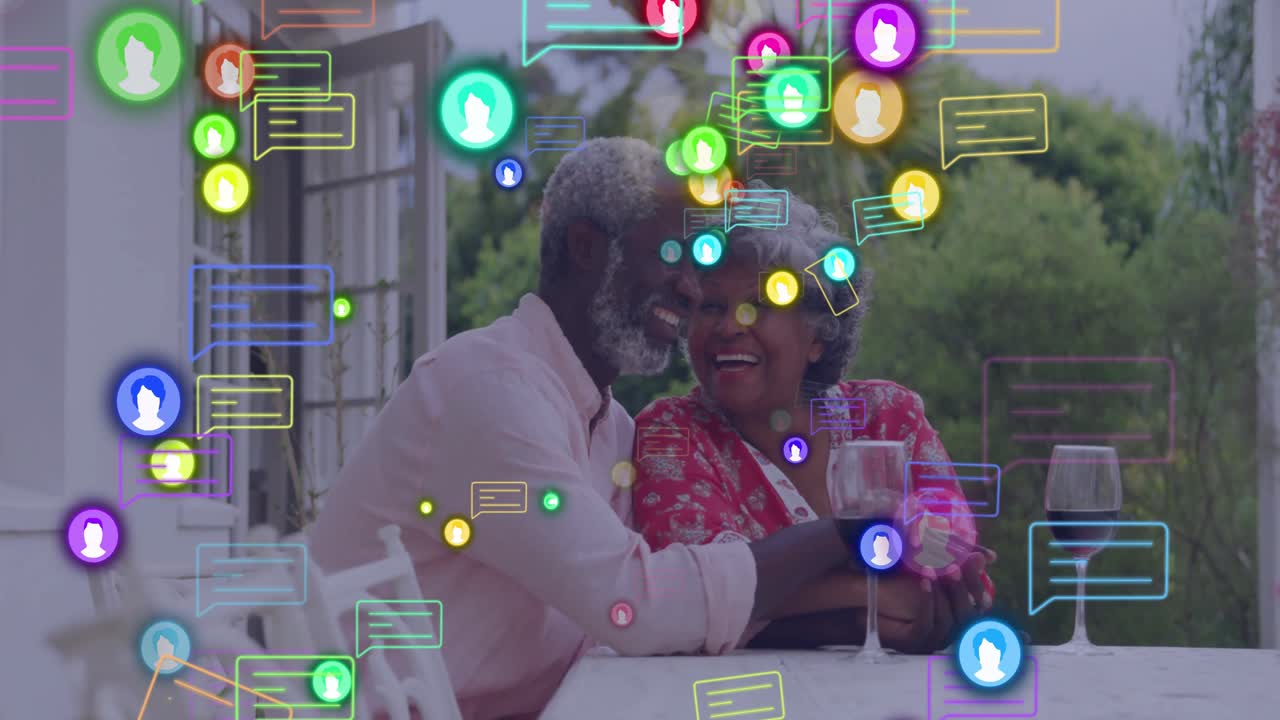 Chat icons swirling, fading around elderly couple kissing on patio, showing social media bond
