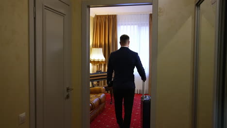 handsome man walking in a hotel room after business meeting. businessman enters apartment in luxury hotel.
