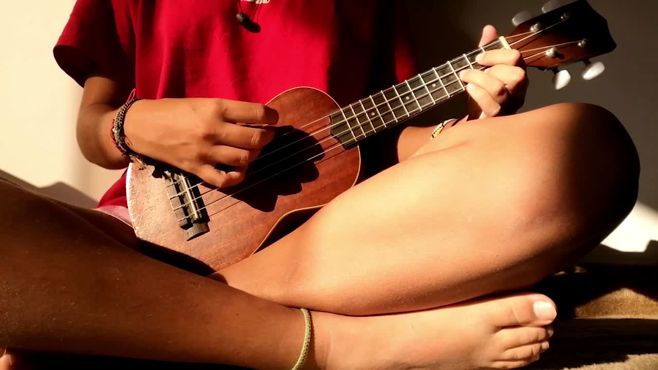 Person Playing Ukulele in Sunlight