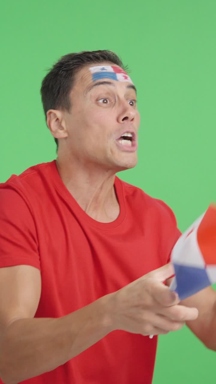 Man cheering for Panama waving a national flag looking away