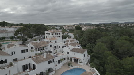 elegant 4k drone footage featuring whitewashed hotel apartments in majorca, spain. captured from above, the clean architecture contrasts beautifully with the surrounding mediterranean landscape