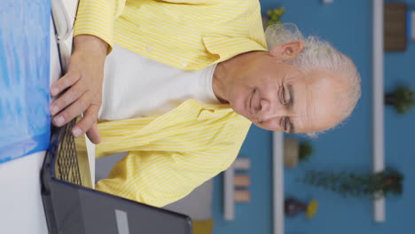 Vertical-video-of-Home-office-worker-old-man-looking-with-satisfied-expression.