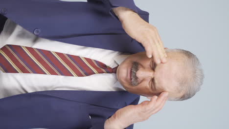 vertical video of old businessman with migraine.