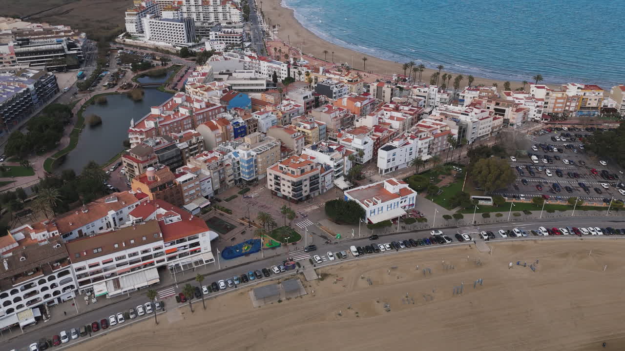 Wide aerial shows Peniscola town and Playa Sur beach with Castell de Peniscola behind