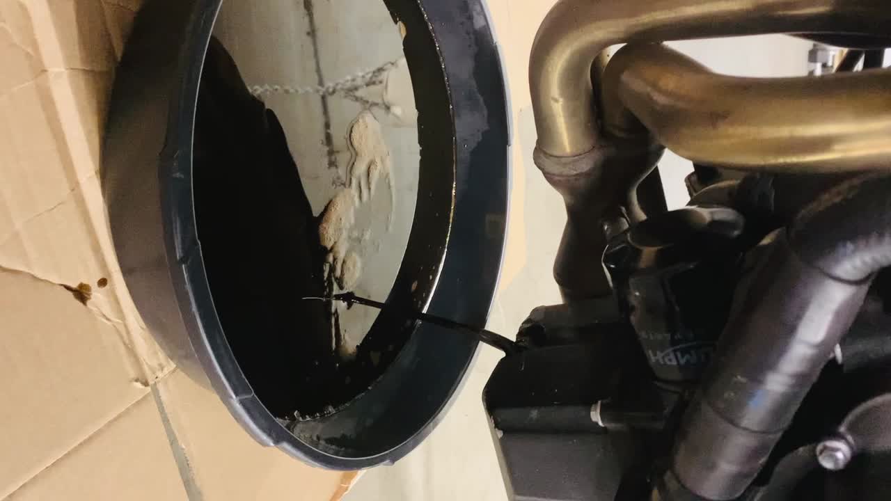 기름을 교체하는 동안 트리 타이거 스포츠 660 모터사이클에서 은 기름이 흘러나옵니다.