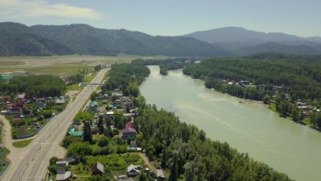 Aerial-Flying-over-tourist-town-in-the-region-of-mountains-mountain-river-and-fields-Also-view-of-the-highway