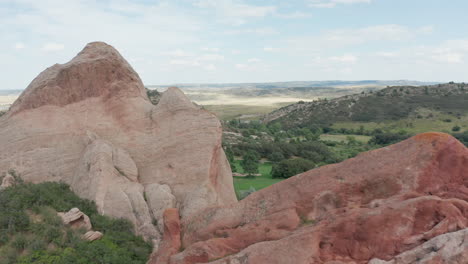 campo de golf de punta de flecha en littleton colorado con césped verde, rocas rojas y cielos azules